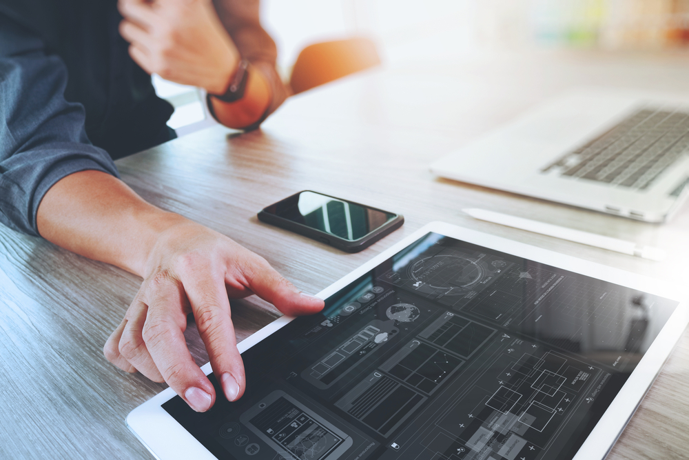 Website designer working digital tablet and computer laptop with smart phone and graphics design diagram on wooden desk as concept Website designer working digital tablet and computer laptop with smart phone and graphics design diagram on wooden desk as concept